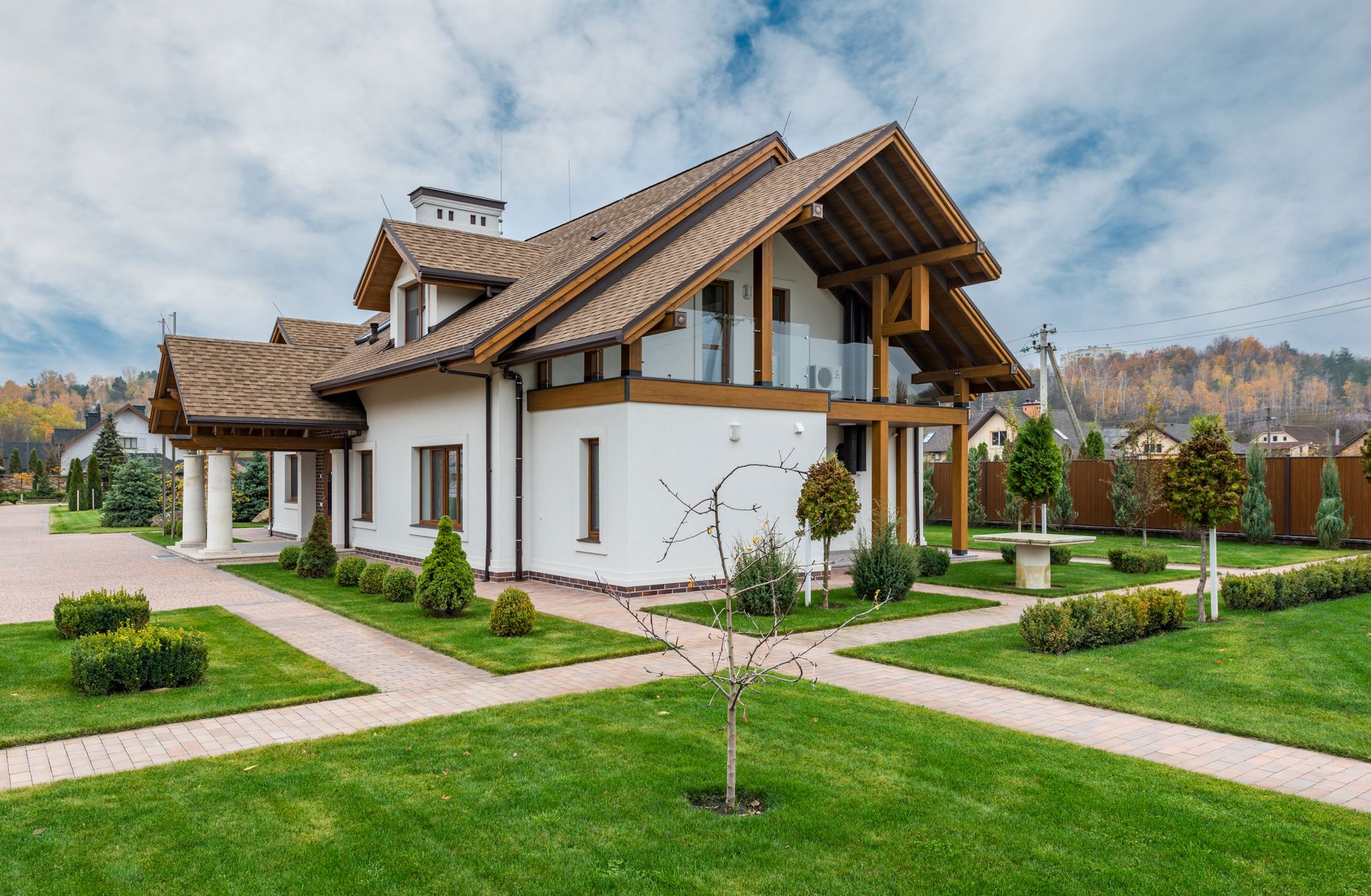 Elegant luxury country home nestled among rolling hills with spacious porch and stone facade