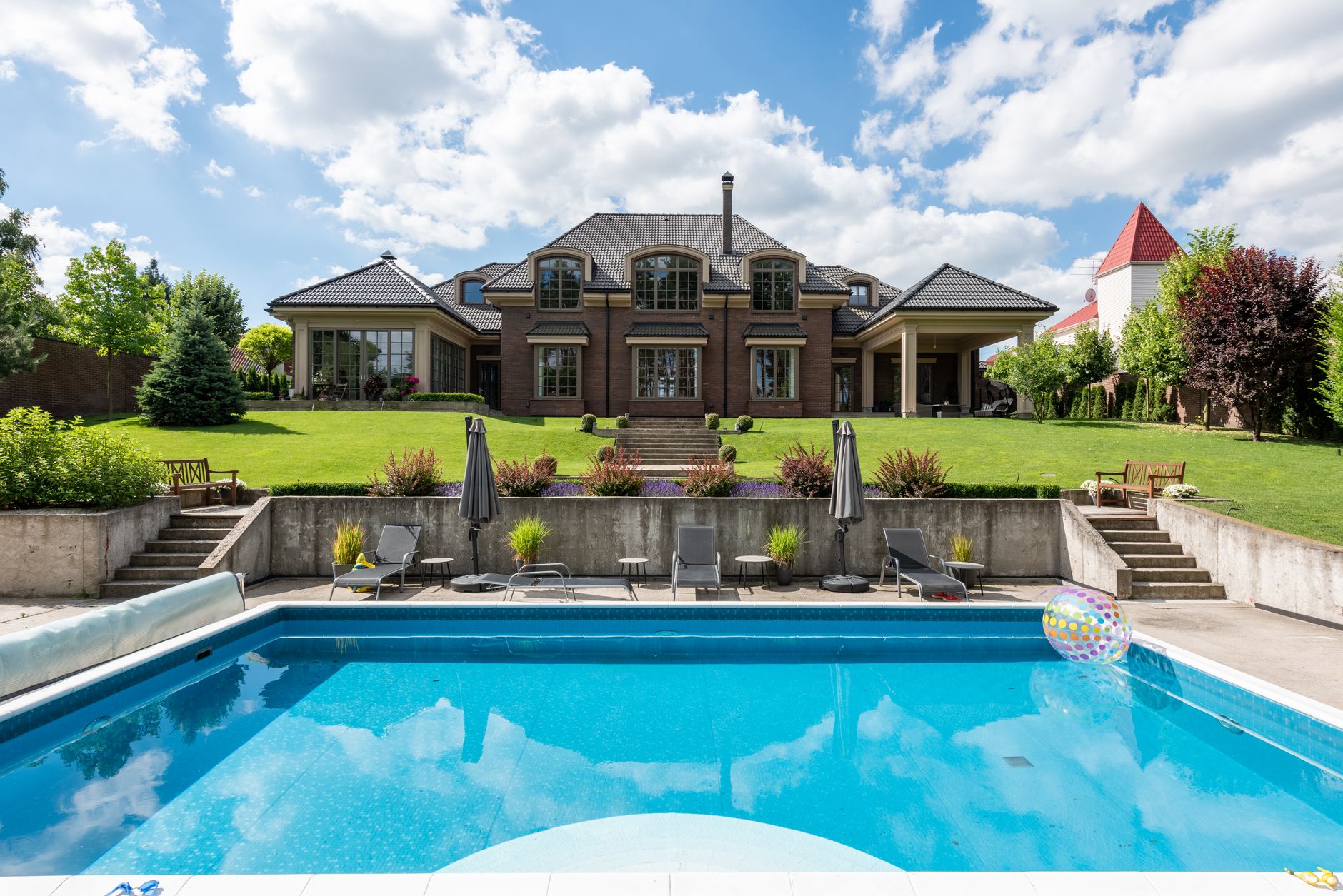 Elegant luxury house featuring a sparkling infinity pool surrounded by sleek architecture and landscaped gardens